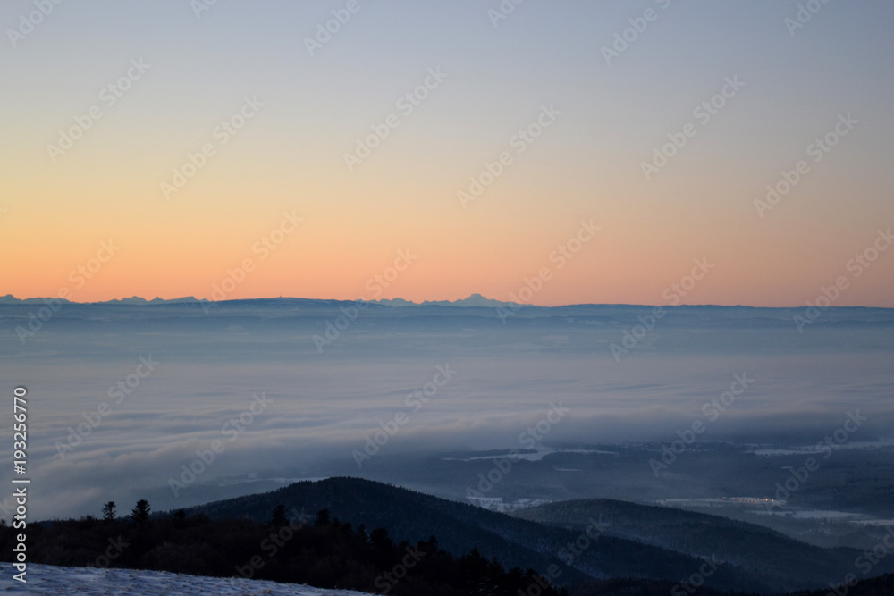 Lever du soleil en montagne,  vue sur les Alpes depuis les Vosges, tons gris orangés, Alsace, France