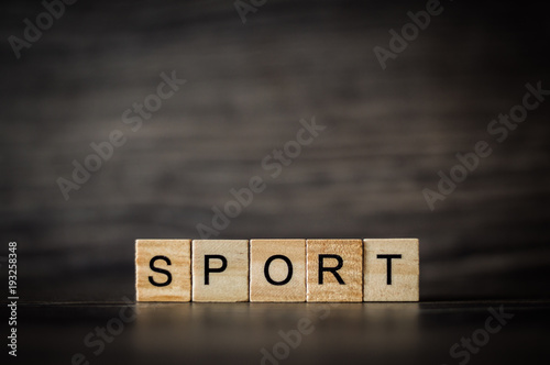 the word sport consisting of a light wooden square panels on a dark wooden background