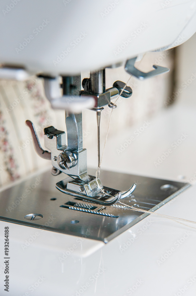 Modern Sewing machine with light flower pattern fabric.