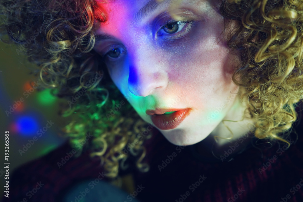 Mujer joven en una habitación oscura con luces de colores Mujer joven en una habitación oscura con luces de colores