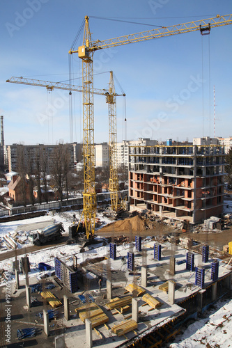 Working crane on the construction of the house. Construction site with cranes on sky background. 