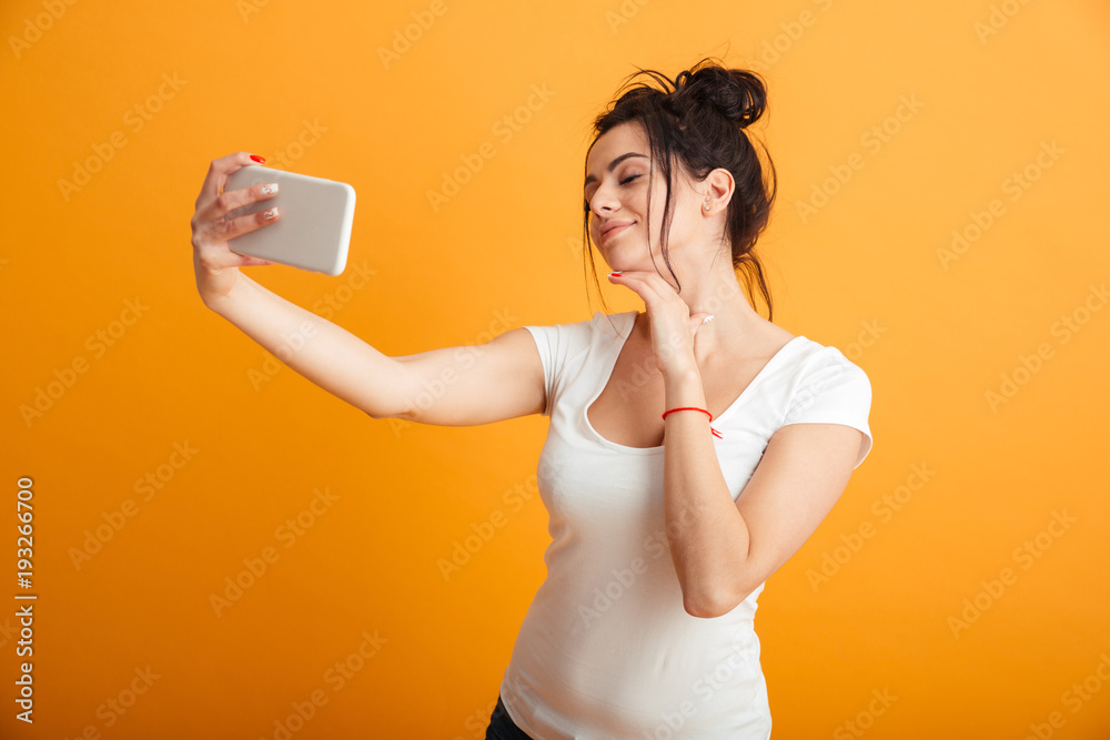 Cheerful young woman make selfie by mobile phone. Cheerful young woman make selfie by mobile phone.