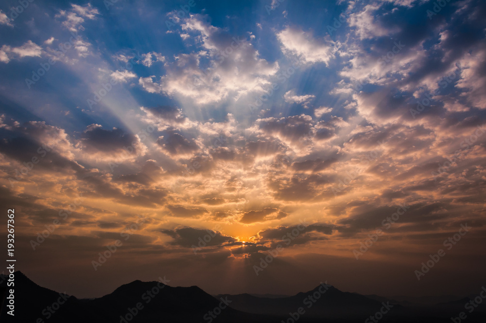 Sunrise rays on morning blue orange sky cloud with mountain