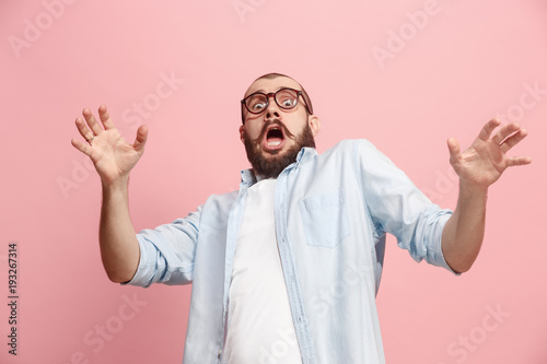 Portrait of the scared man on pink photo