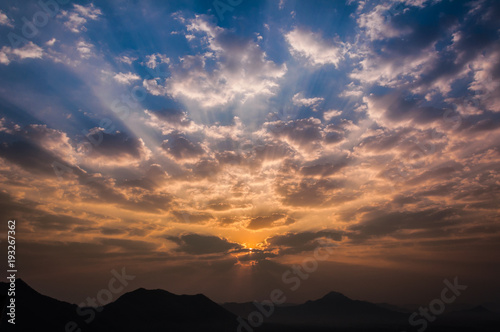 Sunrise rays on morning blue orange sky cloud with mountain