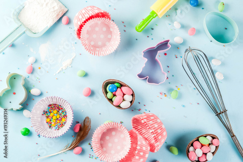 Sweet baking concept for Easter, cooking background with baking - with a rolling pin, whisk for whipping, cookie cutters, sugar sprinkling, flour. Light blue background, top view copy space
