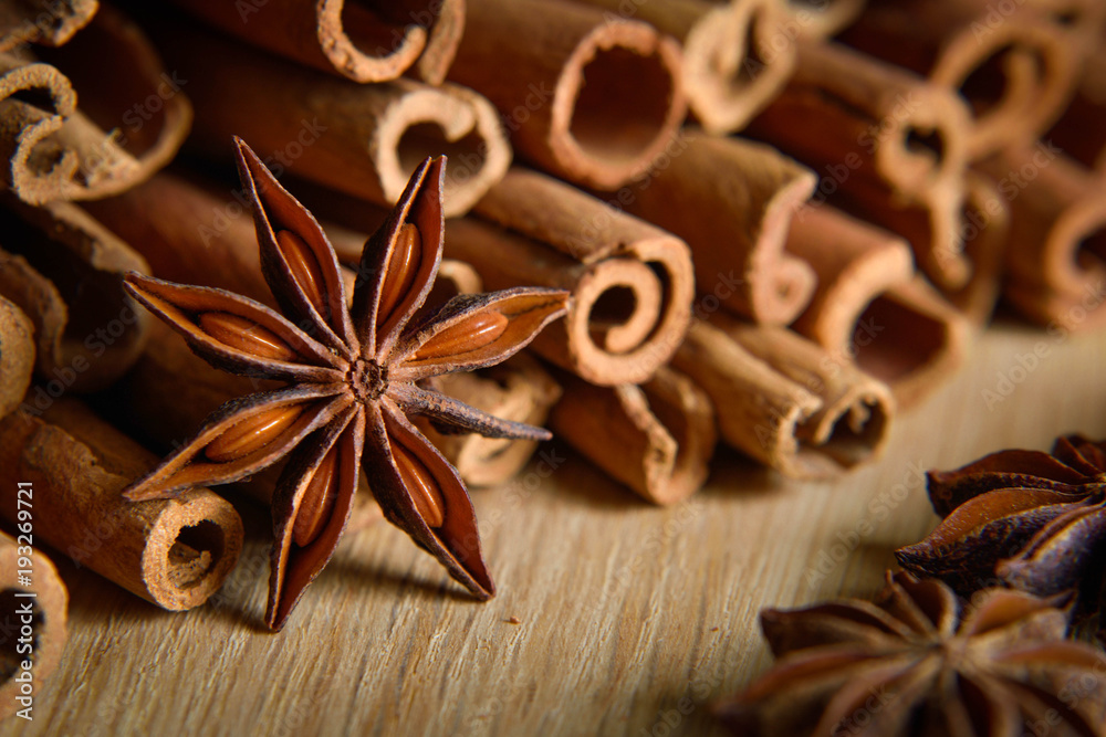 shelves of cinnamon and anise stars in dark backgrounds on a wooden background shelves of cinnamon and anise stars in dark backgrounds on a wooden background
