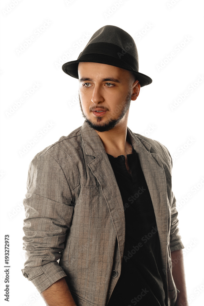 Serious young man in hat and jacket looking away