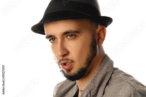 close up portrait of young handsome man in hat and jacket looking aside