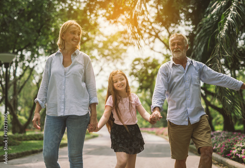 Happy family mother father and daughter walk on nature on sunset hold hand