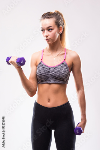 portrait of pretty sporty woman holding weights isolated on white background