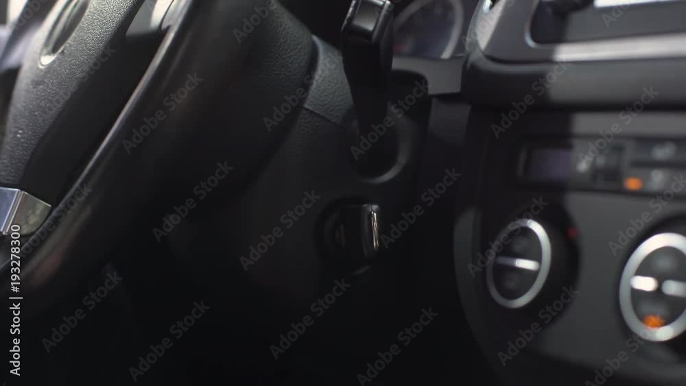 Portrait cropped of male driver in business suit sitting in automobile, and starting his car with key before travel Portrait cropped of male driver in business suit sitting in automobile, and starting his car with key before travel