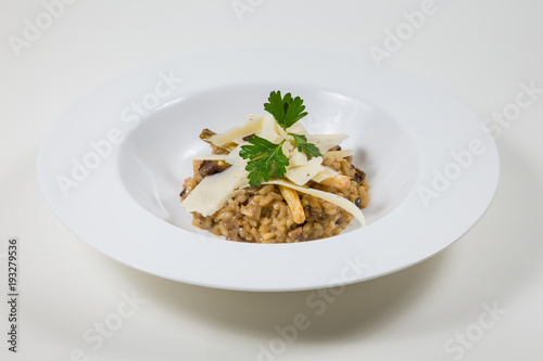 Mushroom risotto with parmesan in a white bowl on a white background isolated