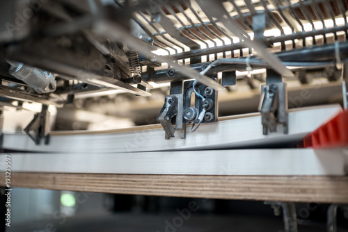Fragment of the offset printing machine during the printing at the manufacturing