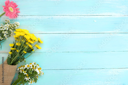 Colorful flowers bouquet on blue wooden background. Concept flowers of spring, top view and border design,