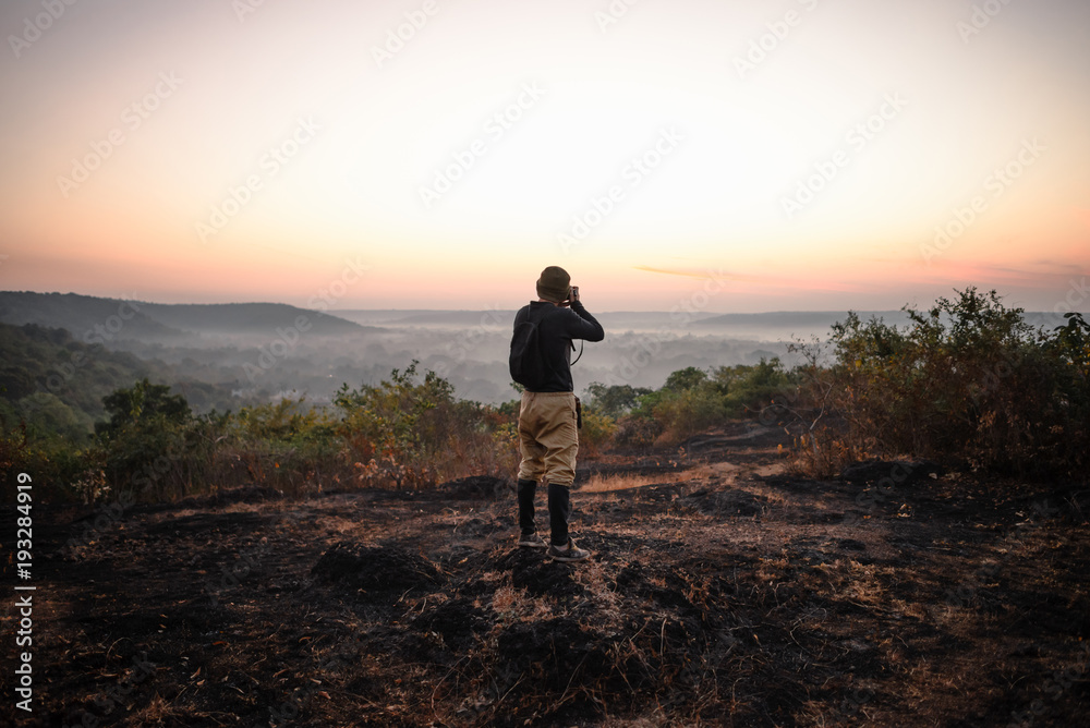 Travel photographer taking a shots at sunrise