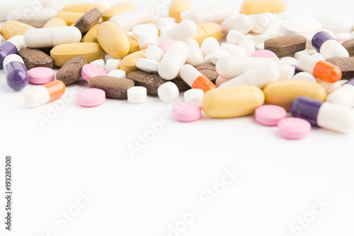 Different colorful pills on white table
