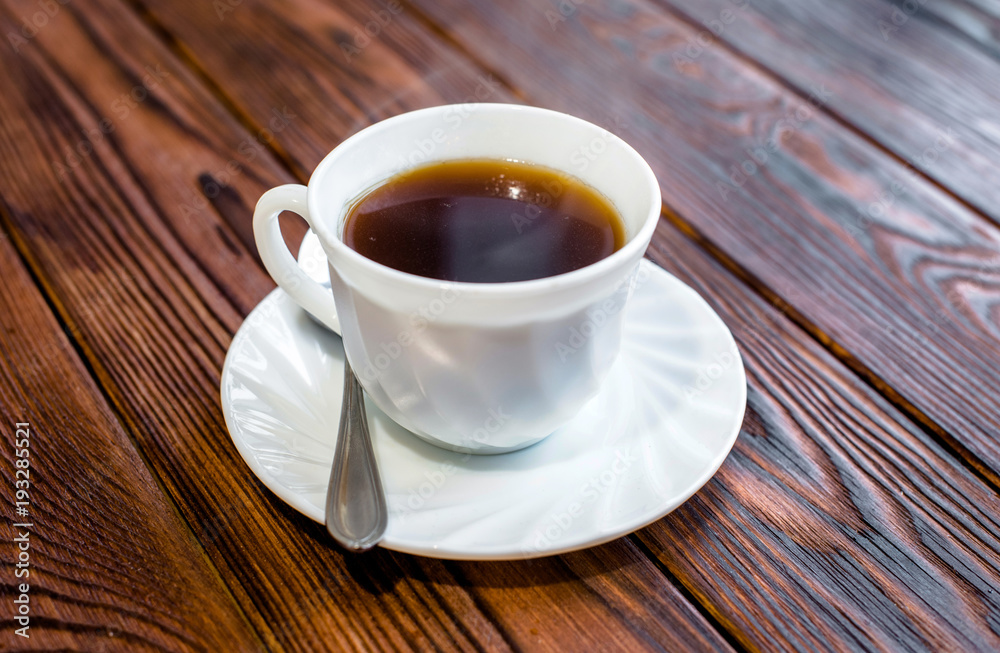 A cup of hot coffee stands on a wooden table A cup of hot coffee stands on a wooden table