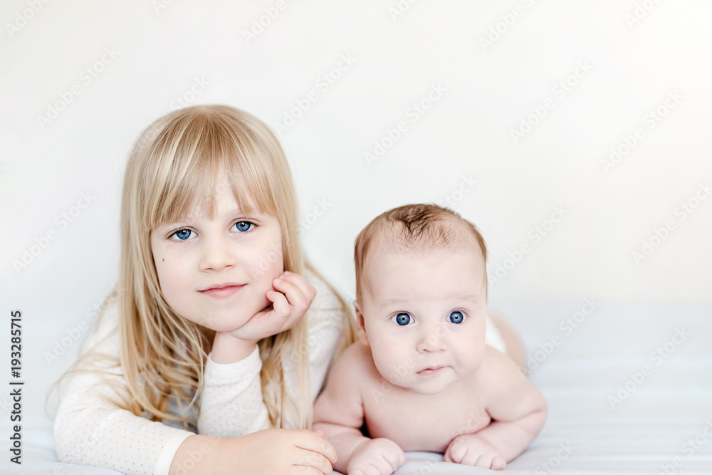 Portrait of brother and sister. Two cute children lying on bed. Brother and sister best friends, happy family and childhood concept Portrait of brother and sister. Two cute children lying on bed. Brother and sister best friends, happy family and childhood concept