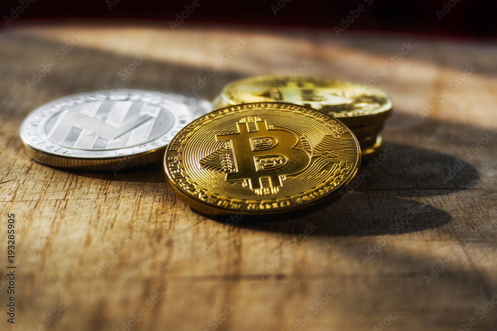 Stack of bitcoinsand litecoin with a single coin above. Photo of shining Bitcoins with golden sunrays. Digital decentralized currency. Stack of bitcoinsand litecoin with a single coin above. Photo of shining Bitcoins with golden sunrays. Digital decentralized currency.