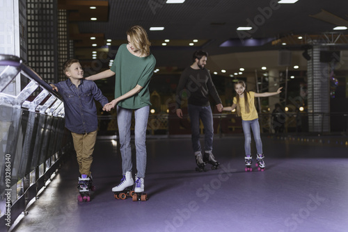 parents and kids skating on roller rink together © LIGHTFIELD STUDIOS