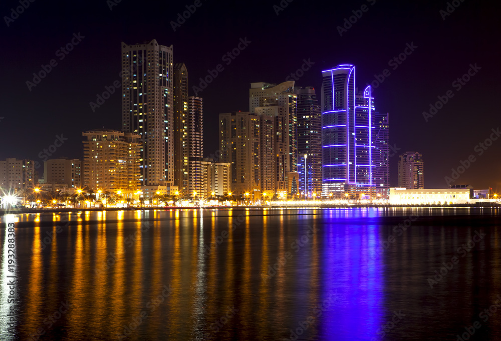 Obraz premium Skyscrapers on the shores of Laguna Khalid. Night view. Sharjah. United Arab Emirates