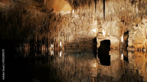 MAJORCA, SPAIN Tourists float on a boat on the underground lake in the famous stalactite caves of Dragon (Cuevas del Drach)