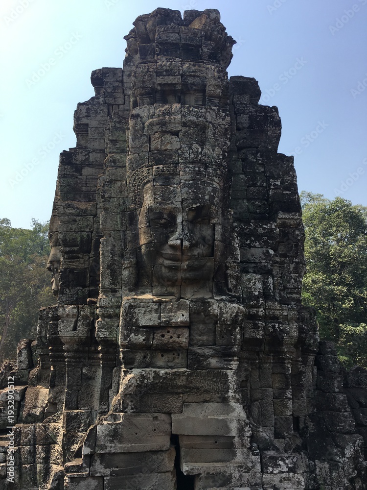 Angkor Wat in Siem Reap, Cambodia. Stone faces carved in the ancient ruins of Bayon Khmer Temple