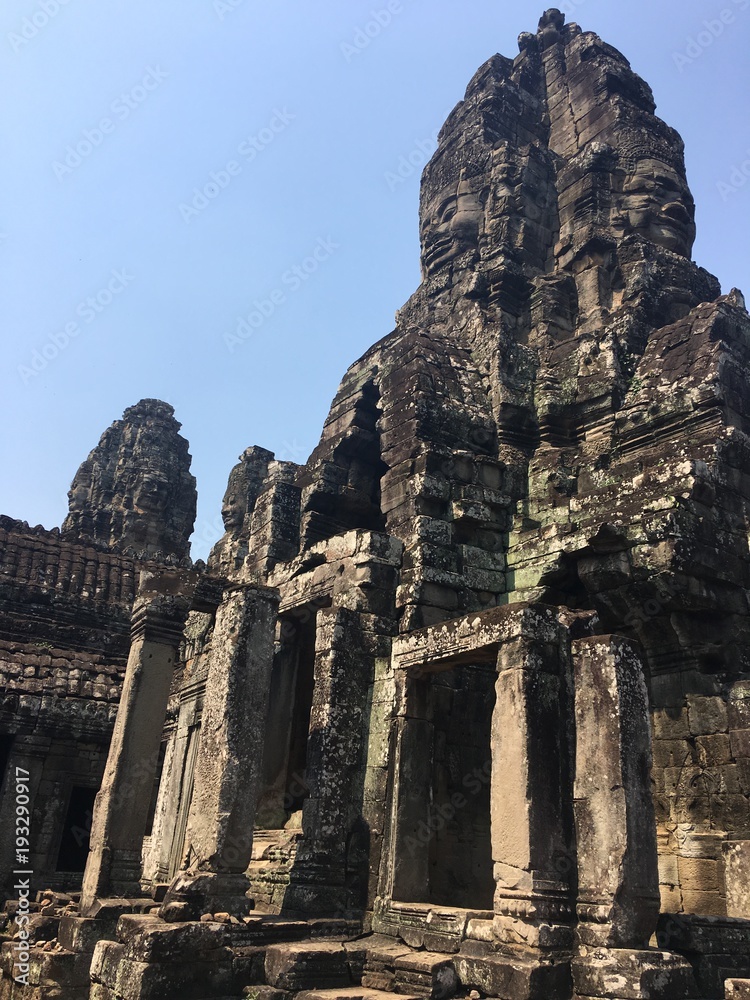 Angkor Wat in Siem Reap, Cambodia. Stone faces carved in the ancient ruins of Bayon Khmer Temple