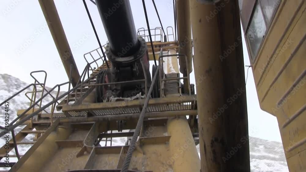 Nodes, parts and working mechanisms of the excavator. The mechanism of an excavator and a crane on which a metal cable is wound. Nodes, parts and working mechanisms of the excavator. The mechanism of an excavator and a crane on which a metal cable is wound.