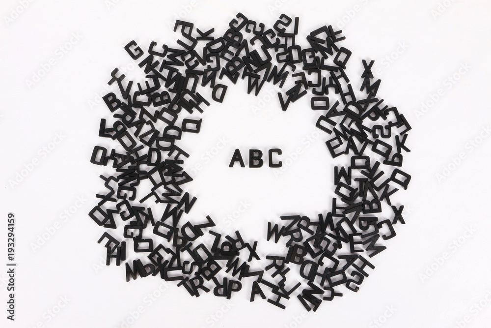 schwarze holzbuchstaben liegen in einem kreis und in der mitte steht abc schwarze holzbuchstaben liegen in einem kreis und in der mitte steht abc