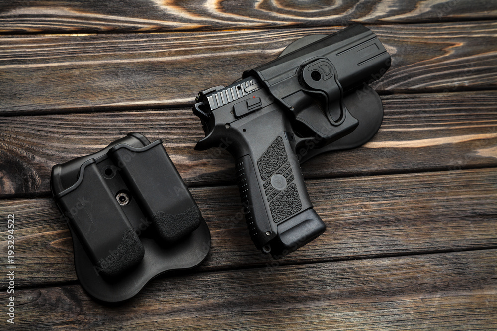 black pistol on a wooden background