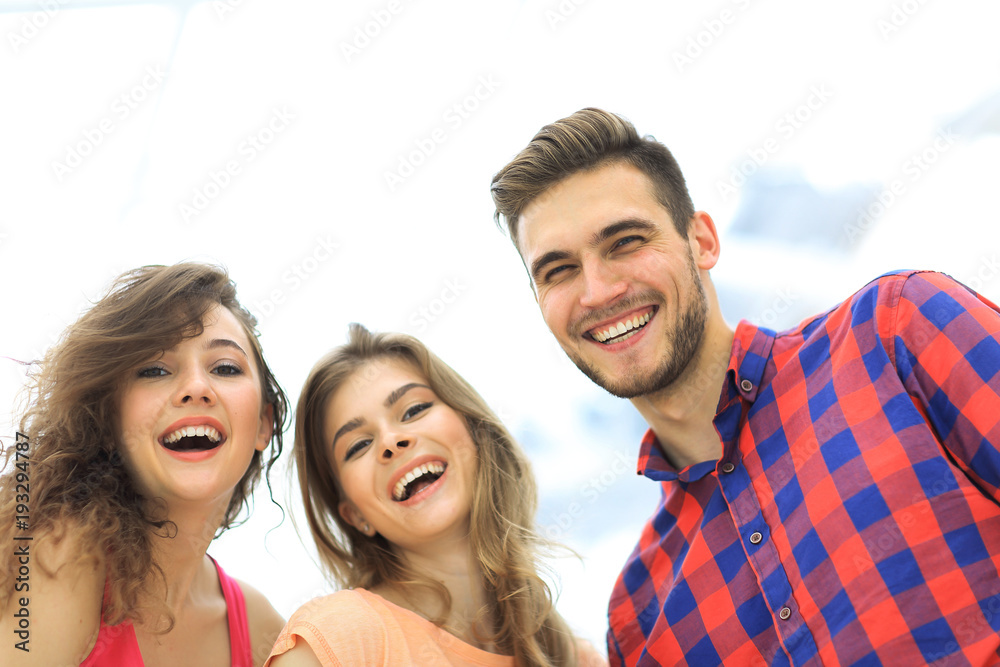 closeup of three young people smiling on white background closeup of three young people smiling on white background
