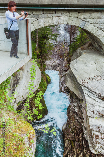 Tourist with camera on Gudbrandsjuvet waterfall, Norway photo