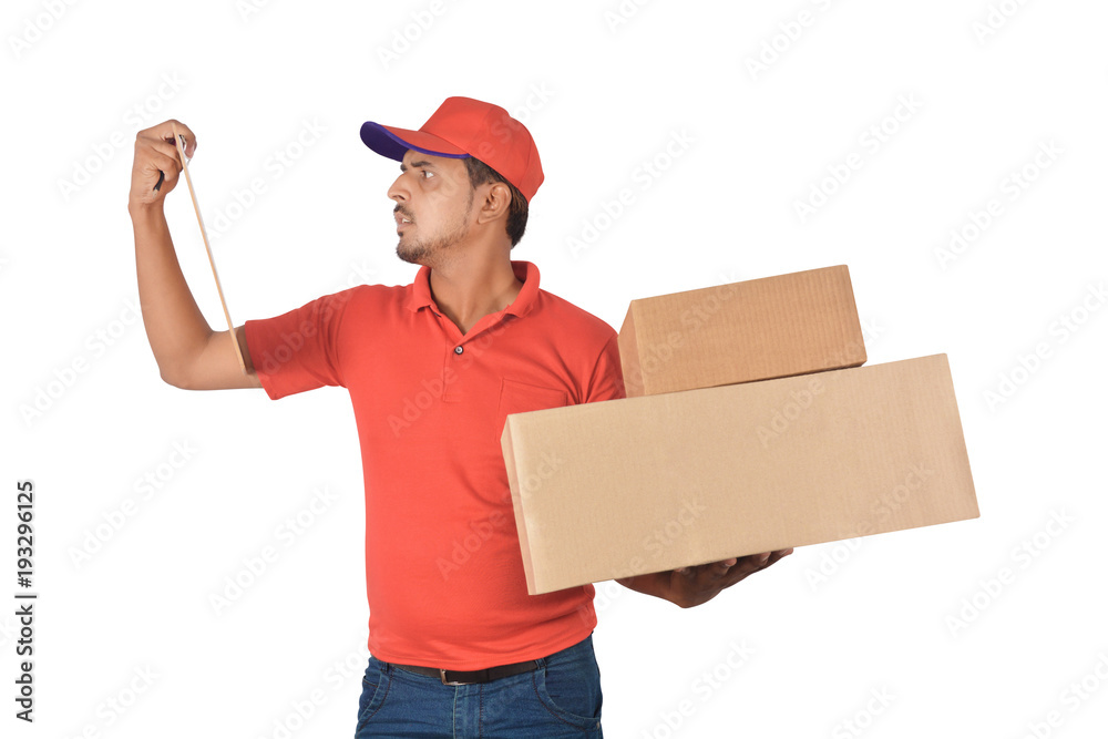 Delivery man holding carton box looking at list in uniform Delivery man holding carton box looking at list in uniform