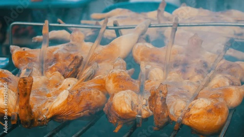 Whole chicken carcass grill strung on wooden stick grilling on the grill. Street Food Thailand photo