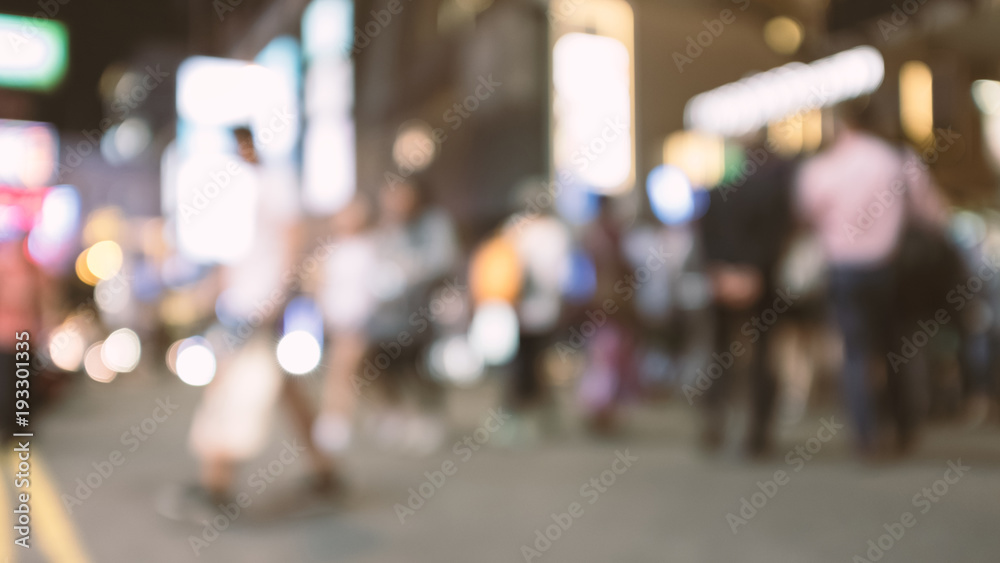 abstract blur and defocused people crossing the street in Hong Kong city at night for background, old film look effect