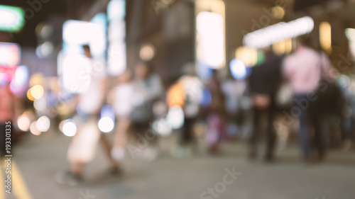 abstract blur and defocused people crossing the street in Hong Kong city at night for background, old film look effect