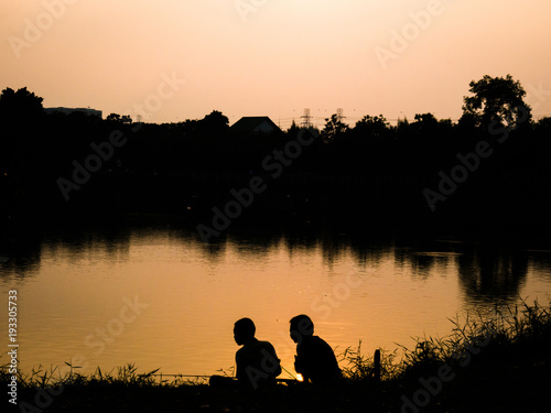 silhouette people background.sitting at public park, edge of swamp,.in felling relax, fun at sunset sky.