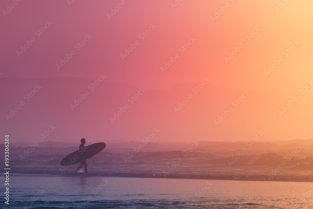 surfer at the sunset with dreamy colors