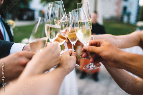 People hold in hands glasses with champagne, friends celebrating and toasting