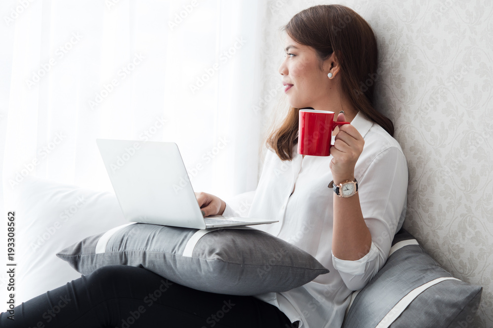 Asian business girl working and drinking coffee in living room Asian business girl working and drinking coffee in living room