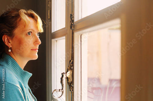 Portrait of beautiful 45 years old woman looking to the window