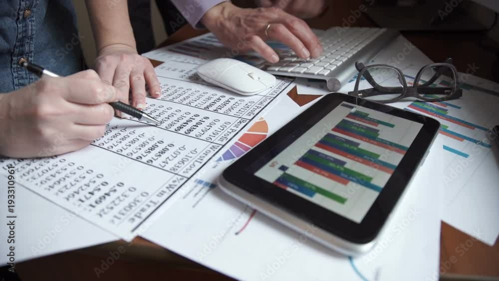 Two young businessmen using touchpad at meeting Two young businessmen using touchpad at meeting