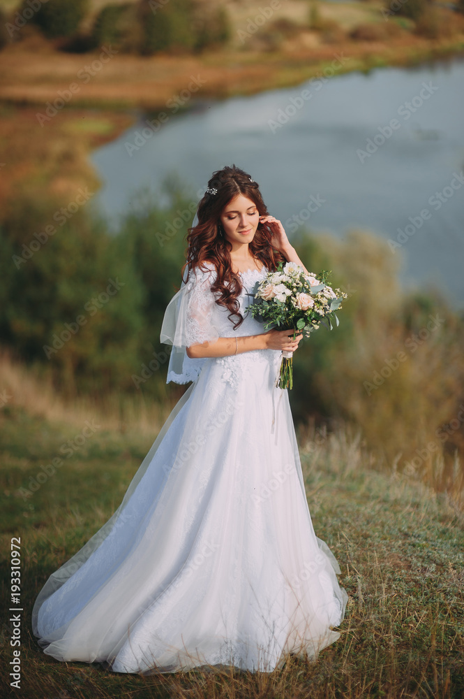 beautiful bride with stylish bouquet on the background of the lake beautiful bride with stylish bouquet on the background of the lake