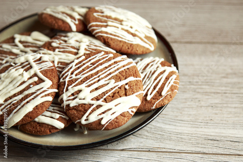 Brown Round Christmas Gingerbread cookies drizzled with White Chocolate on a plate