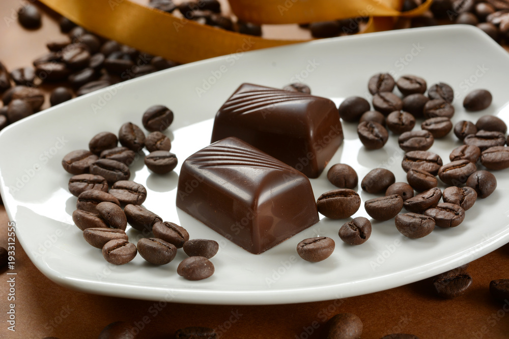 coffee chocolates with coffee beans next to it coffee chocolates with coffee beans next to it
