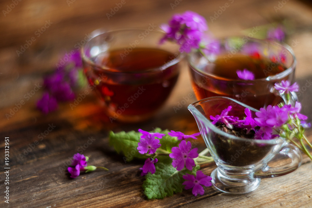 Lime brewed tea in a cup on a wooden table. on a table scattered linden blossoms and leaves Lime brewed tea in a cup on a wooden table. on a table scattered linden blossoms and leaves