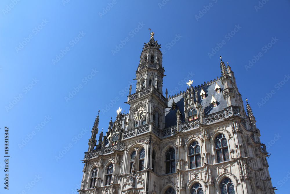 The beautiful 14th century, late gothic style Oudenaarde Town Hall, in East Flanders in Belgium. Against a background of blue sky with copy space.