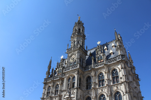 The beautiful 14th century, late gothic style Oudenaarde Town Hall, in East Flanders in Belgium. Against a background of blue sky with copy space.
